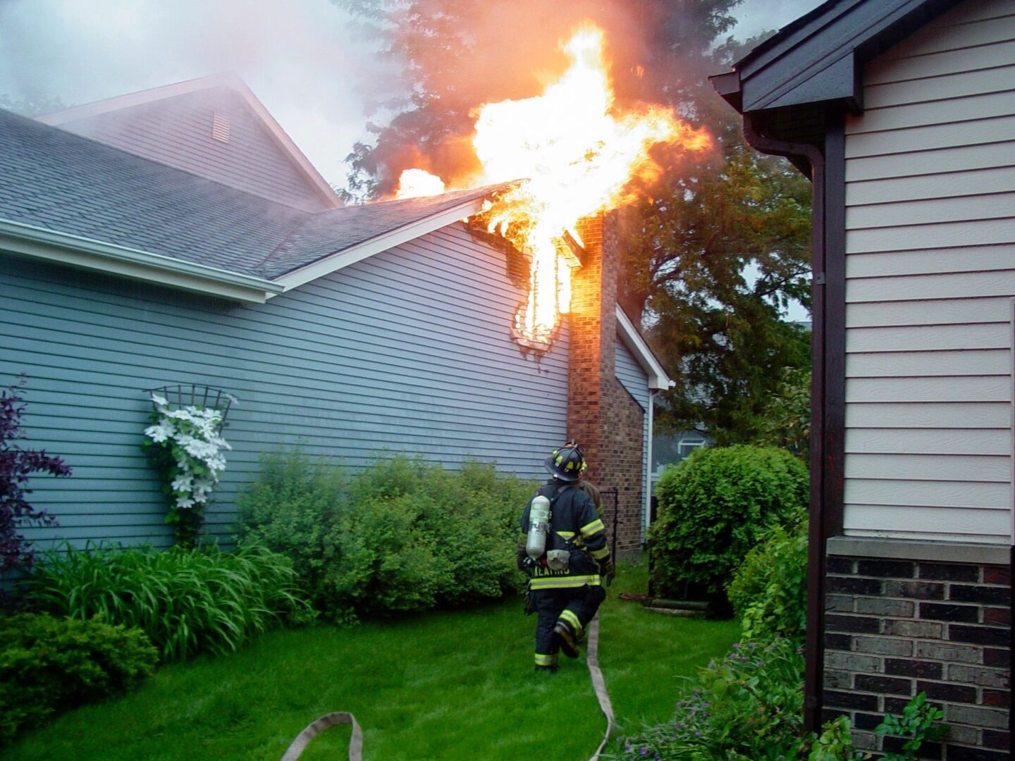 a fireman running towards a burning house